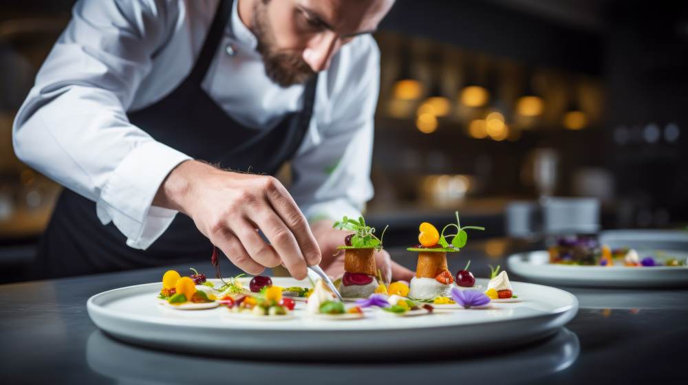 Cuisinier dressant une assiette en cuisine professionnelle