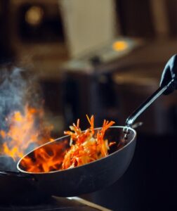 Modern kitchen. Cooks prepare meals on the stove in the kitchen of the restaurant or hotel. The fire in the kitchen.