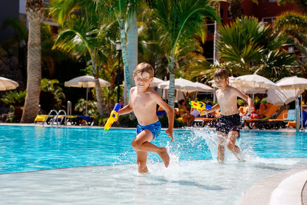 Deux enfants qui s'amusent à la piscine de l'hôtel