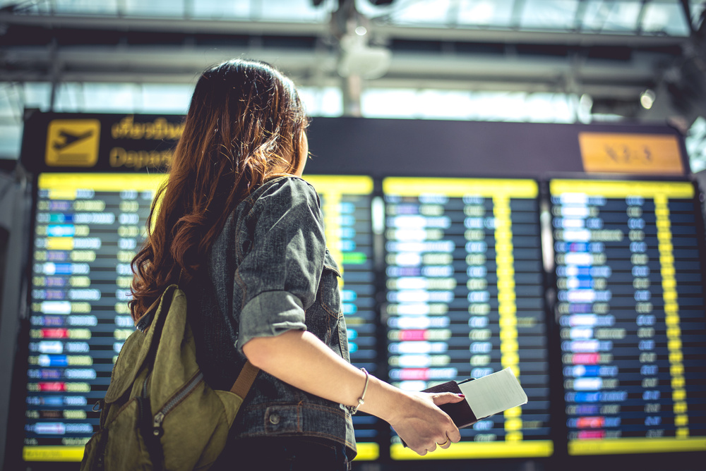Une femme regarde l'écran des vols, aéroport