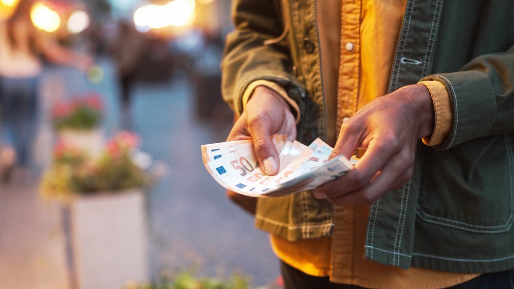 Voyageur comptant des billets en euros, budget de voyage en main